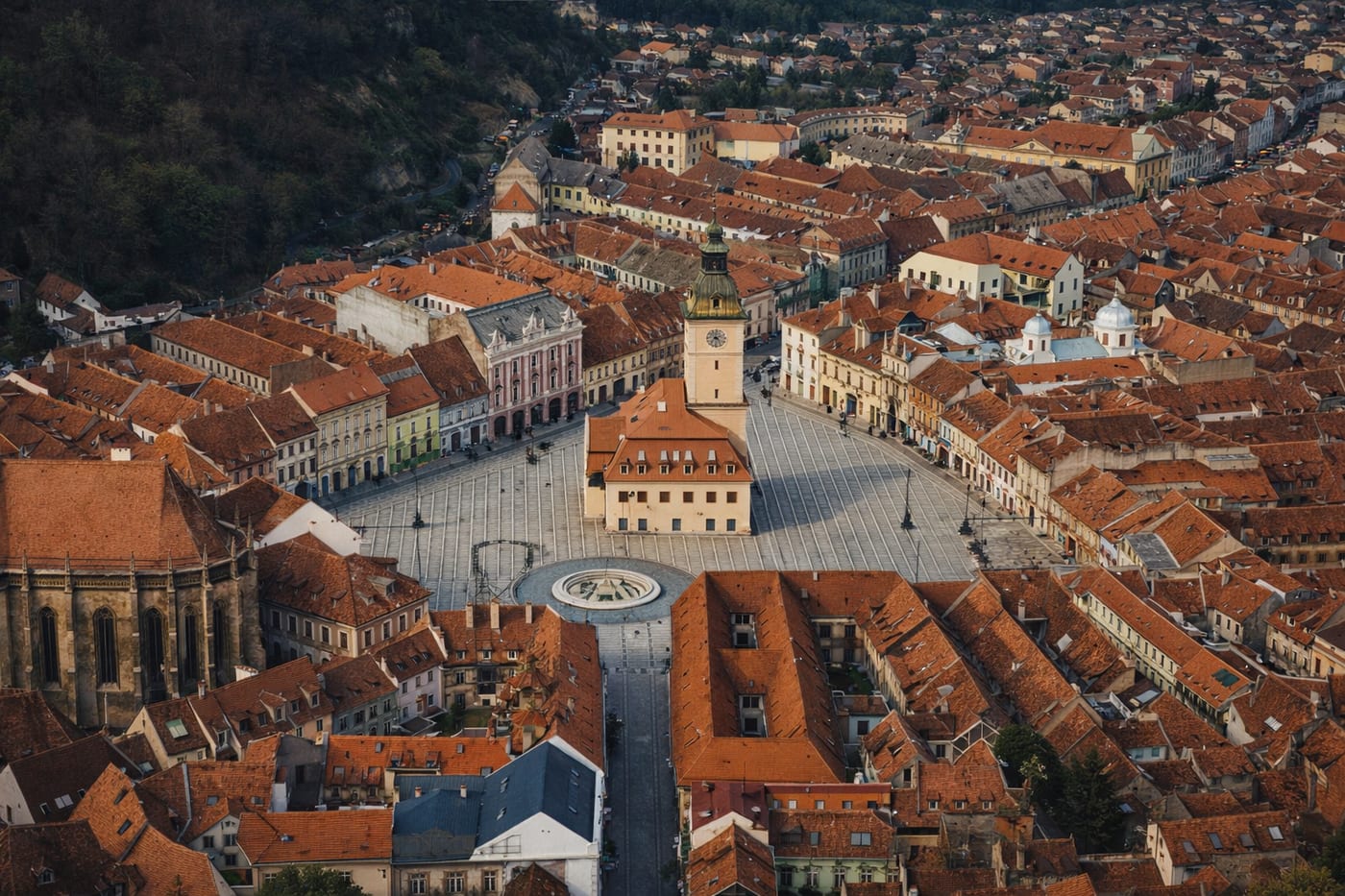 Aerial view of Brașov's Council Square and the old town's red-tiled rooftops