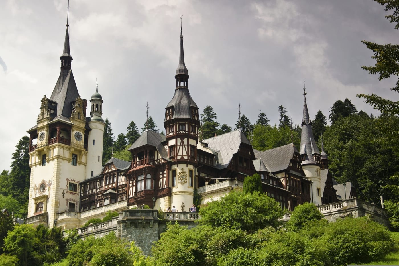 Peleș Castle's turrets rising above the forest in Transylvania